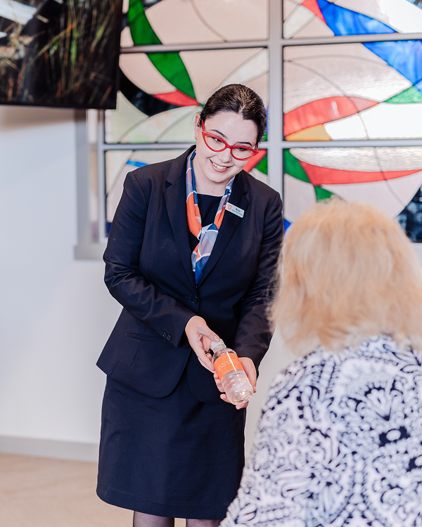 Gatton funeral director giving a water bottle to a woman