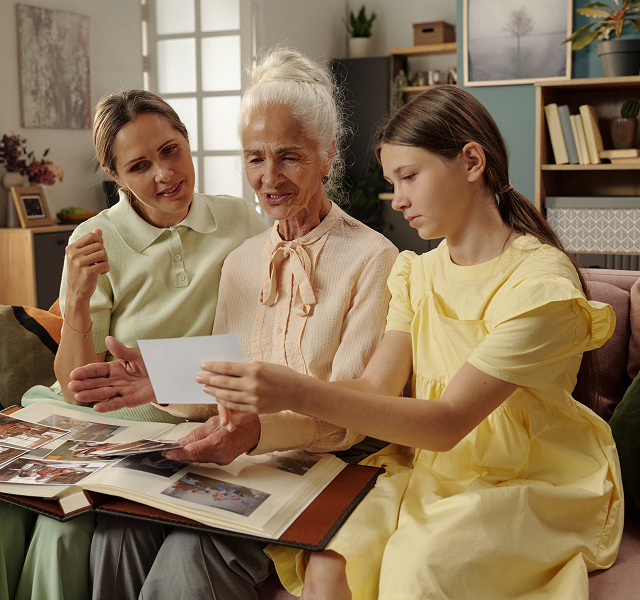 three woman looking at photos